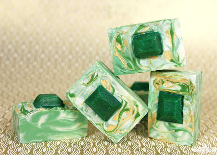 This Emerald Swirl Cold Process Soap Tutorial uses melt and pour embeds and mica painting to create a sophisticated and eye-catching design.