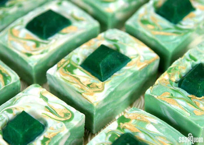 This Emerald Swirl Cold Process Soap Tutorial uses melt and pour embeds and mica painting to create a sophisticated and eye-catching design.