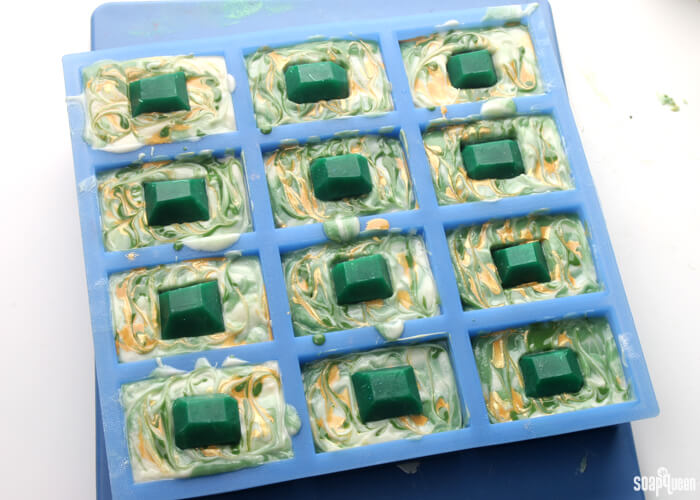 This Emerald Swirl Cold Process Soap Tutorial uses melt and pour embeds and mica painting to create a sophisticated and eye-catching design.
