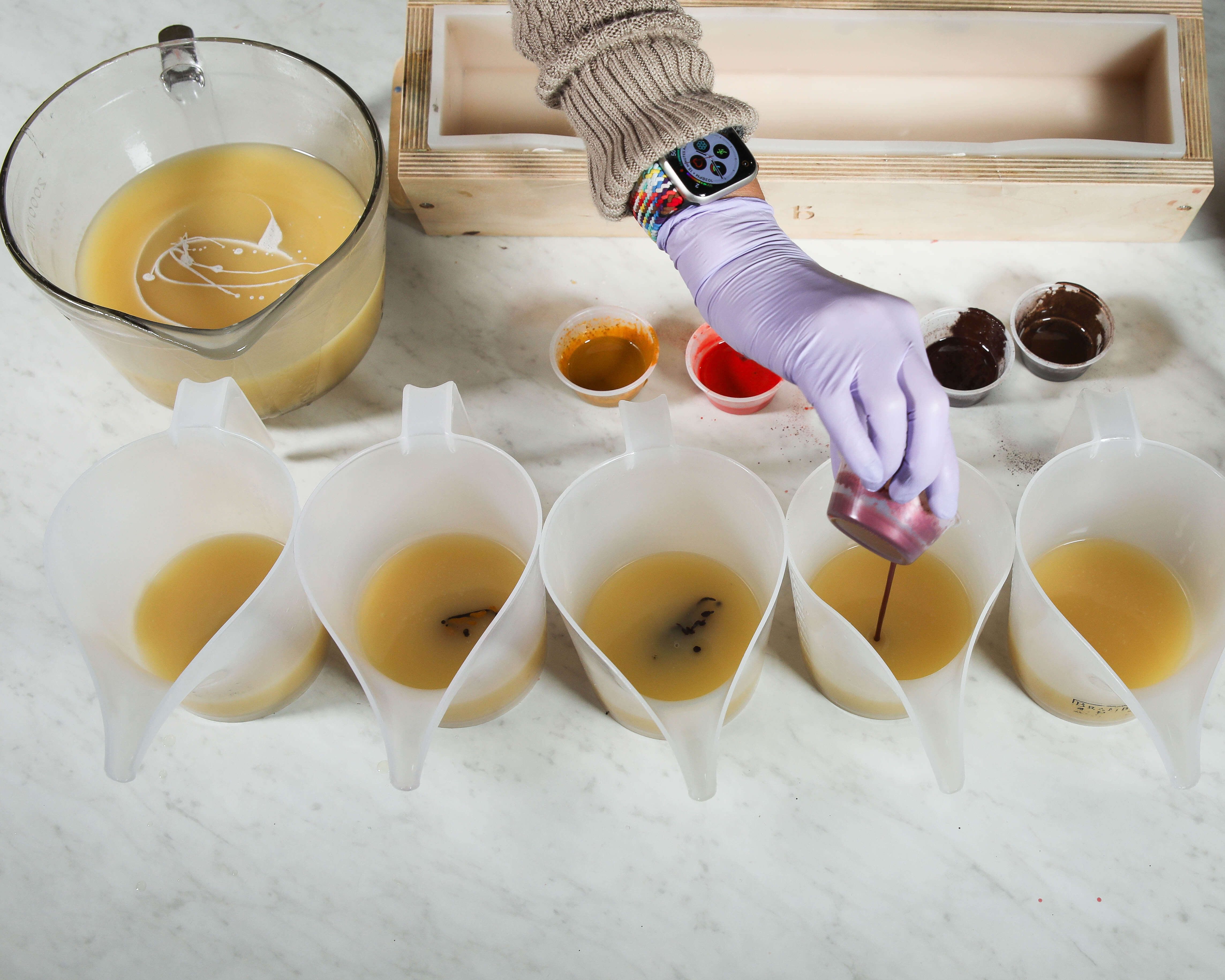 Adding color into soap base Soap in multiple containers, with colorant being added