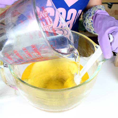 Pouring lye in oils to make cold process soap.