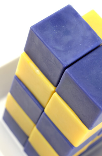 Blue and yellow cube soap stacked in a high tower.