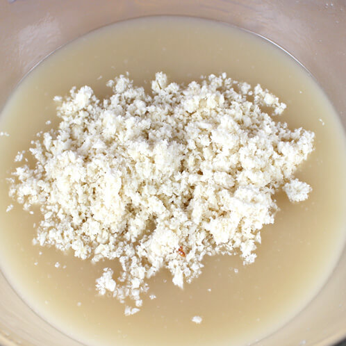 Adding almond meal to cold process soap batter.