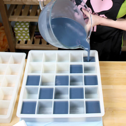 Anne-Marie pours the blue soap into cube molds.
