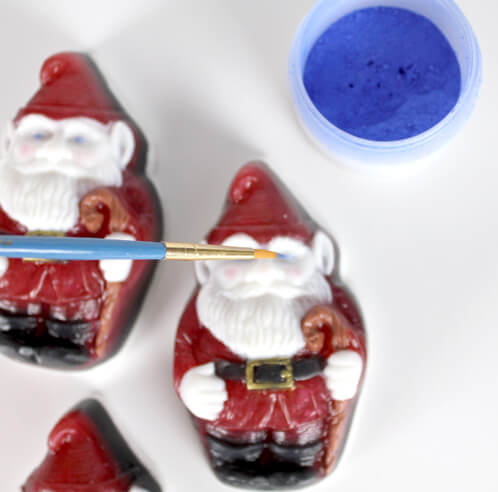 Brushing mica on the santa gnomes for a finishing touch.