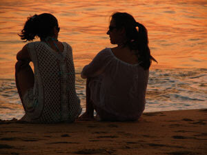 Two friends sitting on a beach