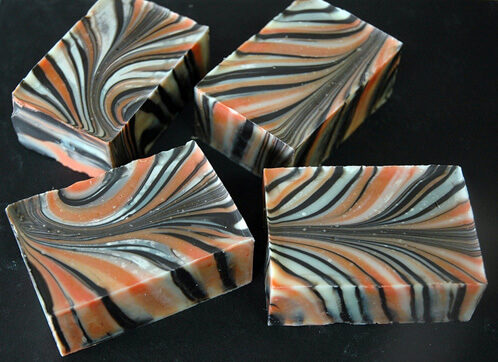 Black, white and orange swirled cold process soap.