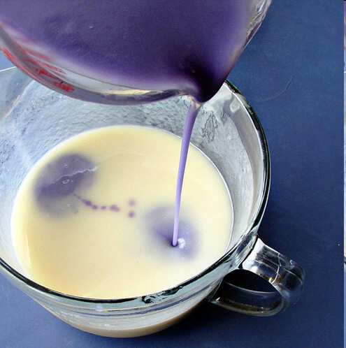 Purple being poured in the white soap batter for In The Pot Swirl.