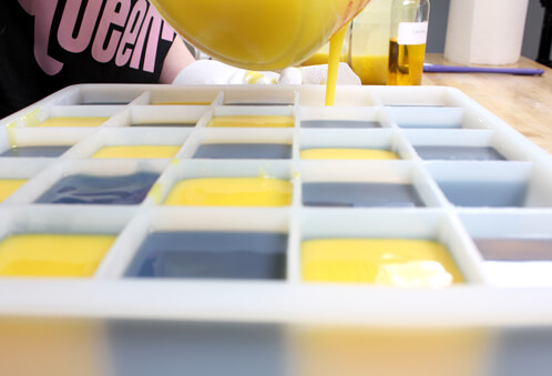 Anne-Marie pours the yellow soap into the cube mold.